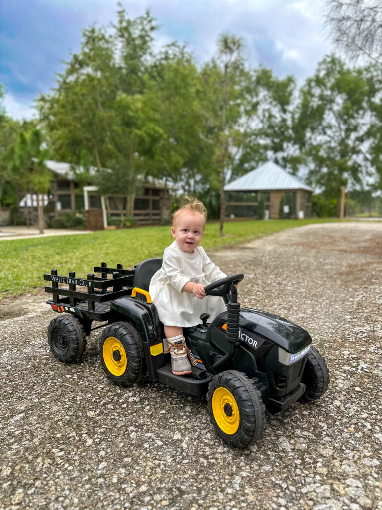 Petting zoos in Jupiter Florida- child riding an electric toy tractor 